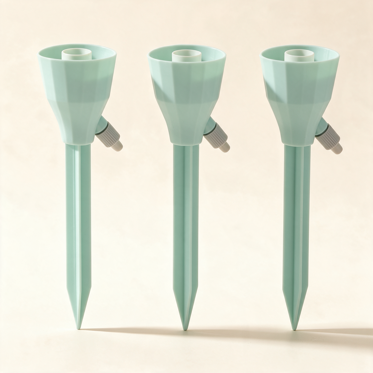 Set of three mint-green bottle-top drip spikes for potted plants.