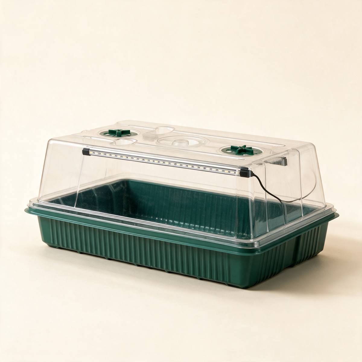 Green seed starter kit with clear dome and LED grow light strips.